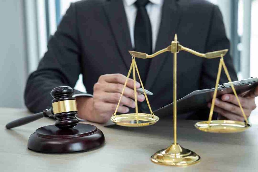 Lawyer reviewing documents with scales of justice and a gavel on the table.